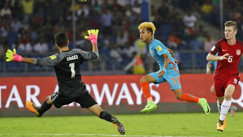India's Komal Thatal kicks the ball as U.S goalkeeper Justin Garces jumps to block it during their FIFA U-17 World Cup match in New Delhi, India, Friday, Oct. 6, 2017. (AP Photo/Tsering Topgyal)