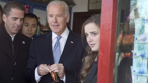 FILE: Former U.S. Vice President Joe Biden, center, buys an ice-cream at a shop as he tours a Hutong alley with his granddaughter Finnegan Biden, right, and son Hunter Biden, left in Beijing, China. (Photo by Andy Wong-Pool/Getty Images)