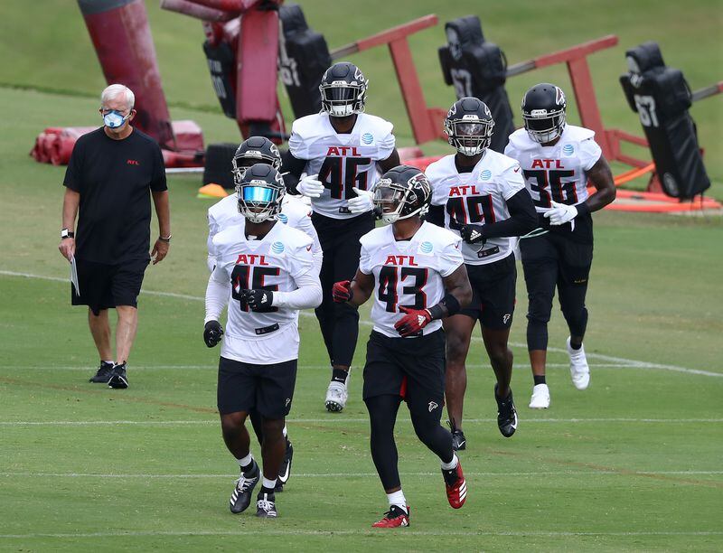 Falcons veteran Deion Jones (left) and rookie Mykal Walker (right) lead the linebackers to the next set of drills.    Curtis Compton ccompton@ajc.com
