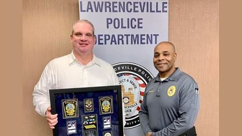 Lawrenceville Police Captain Ryan Morgan, left, seen here as the department celebrated his retirement in December 2021. He's pictured with Major Myron Walker, right, the agency's assistant chief. Morgan informed the city of his decision to retire the night before he was set to be interviewed by an independent investigator looking into sexual harassment within the agency.