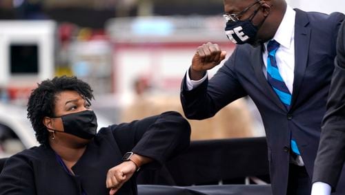 Then Democratic U.S. Senate candidate Raphael Warnock bumps elbows with Stacey Abrams during a campaign rally with then U.S. President-elect Joe Biden at Pullman Yard on Dec. 15, 2020 in Atlanta. Abrams is running to unseat Gov. Brian Kemp and Sen. Warnock is running against former NFL star Herschel Walker. (Drew Angerer/Getty Images/TNS)