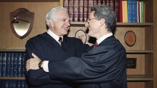 In this Friday, Oct. 13, 1989, file photo, retired Judge Joseph A. Wapner of TV's 'The People's Court' congratulates his son, Judge Frederick N. Wapner, right, as he was enrobed as a Municipal Court judge in Los Angeles. Wapner, who presided over "The People's Court" with steady force during the heyday of the reality courtroom show, has died. Wapner died at home in his sleep Sunday, Feb. 26, 2017, according to his son, David Wapner. (AP Photo/Nick Ut, File)