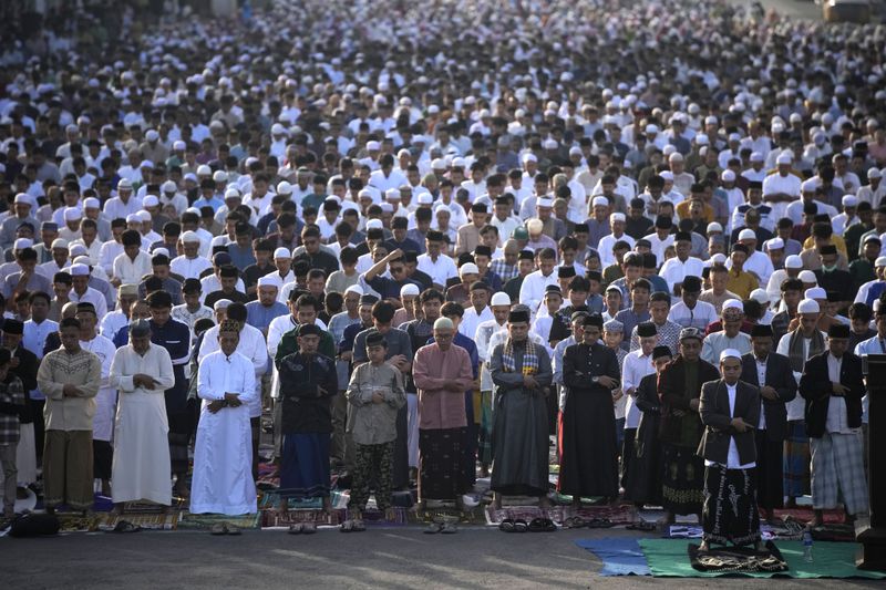 Muslim men perform an Eid al-Fitr prayer marking the end of the holy fasting month of Ramadan on a street in Jakarta, Indonesia, Wednesday, April 10, 2024. (AP Photo/Dita Alangkara)