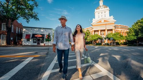 Madison Downtown, CVB Director Jennifer Rosa and husband stroll through downtown Madison with Morgan County Courthouse visible in the background.
(Courtesy of Madison Morgan CVB)