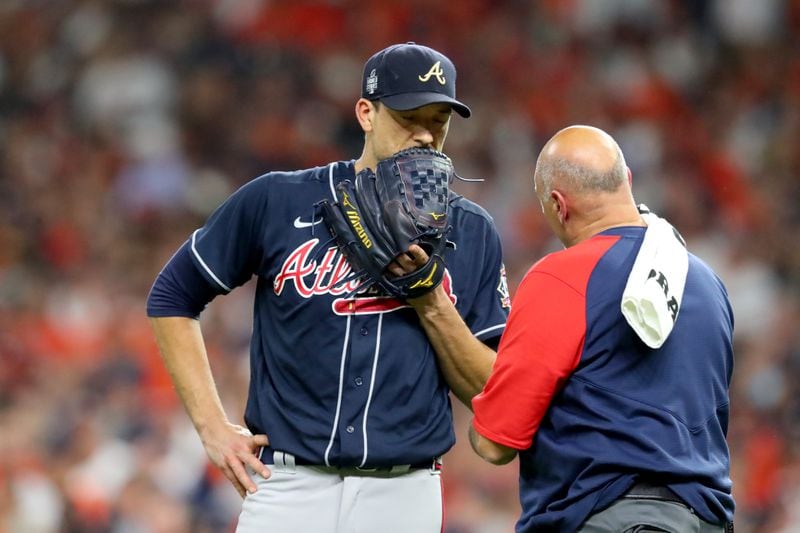 Braves starting pitcher Charlie Morton is tended to by an athletic trainer during the third inning against the Houston Astros in Game 1 of the World Series Tuesday, Oct. 26, 2021, at Minute Maid Park in Houston. Morton left the game with a broken fibula. (Curtis Compton / curtis.compton@ajc.com)