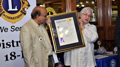 The president of the Namaste Lions Club Chapter Ramesh Gude (left), receives the new club’s charter from Past International Director Kembra Smith. MARTY FARRELL FOR THE AJC