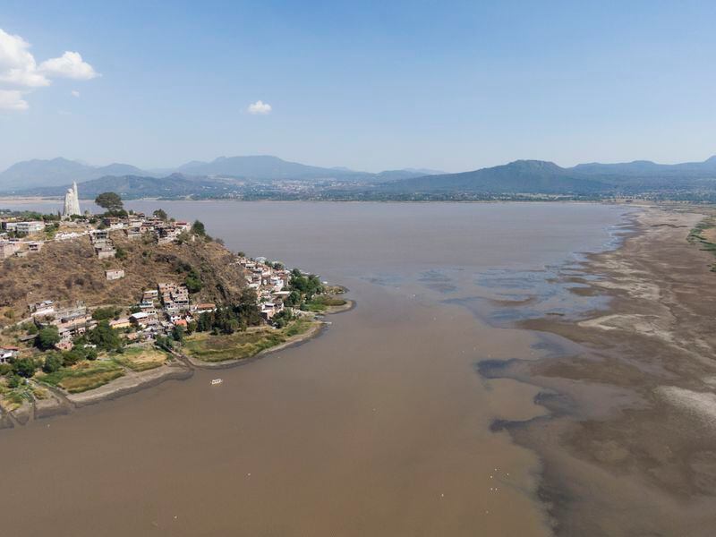Janitzio Island stands in Lake Patzcuaro, which has low water levels during a drought in Mexico, Thursday, April 18, 2024. Farmers are starting to pasture livestock and plant crops on the lake bed. (AP Photo/Armando Solis)