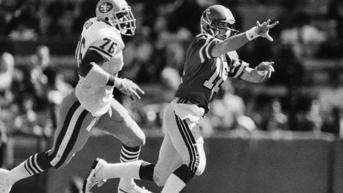 Archer dumps the ball to a close teammate before being sacked by the 49ers in 1985. Louie Favorite / AJC