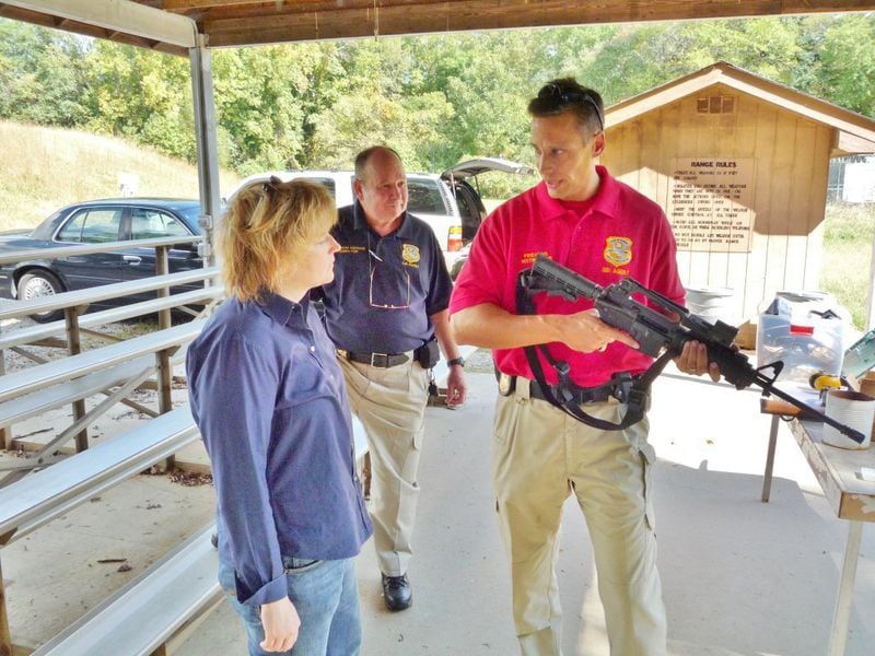 Author Karin Slaughter gets a shooting lesson from GBI Inspector John Heinen. The man in the blue shirt is GBI director Vernon Keenan.

Credit: John Bankhead, GBI