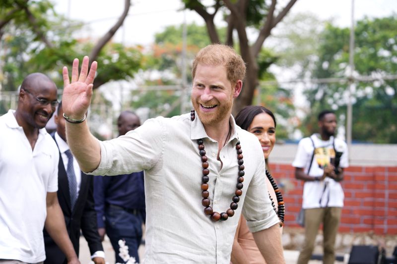 Prince Harry gestures as he and Meghan visit children at the Lights Academy in Abuja, Nigeria, Friday, May 10, 2024. Prince Harry and his wife Meghan have arrived in Nigeria to champion the Invictus Games, which he founded to aid the rehabilitation of wounded and sick servicemembers and veterans. (AP Photo/Sunday Alamba)