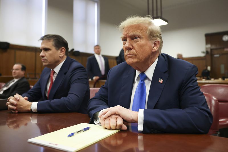 Former President Donald Trump, right, appears in a Manhattan court Monday for opening statements in his trial for allegedly covering up hush money payments. An Emory University professor recently contributed to a book about Trump.