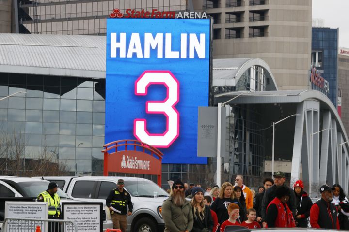 People pass by a sign outside State Farm Arena that shows support for Bills safety Damar Hamlin. Hamlin is recovering from a cardiac arrest suffered last Monday in Cincinnati. (Miguel Martinez / miguel.martinezjimenez@ajc.com)