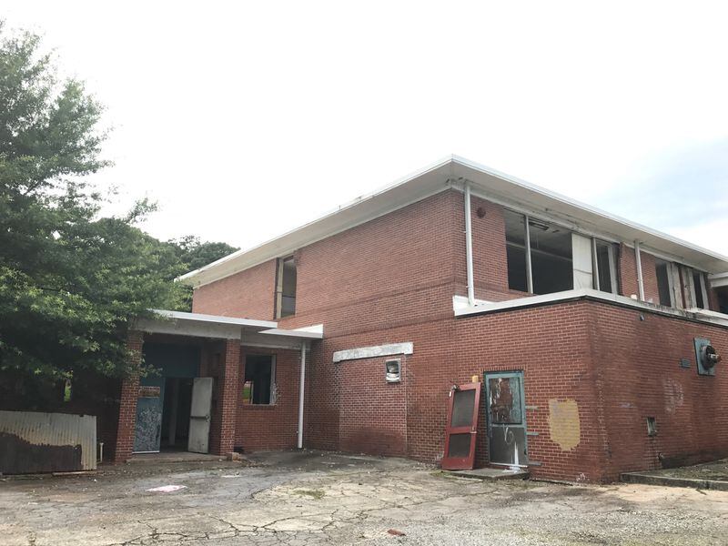 A side view of the former Ragsdale Elementary School shows removed windows and open doors as Atlanta Public Schools begins the process of demolishing the building. VANESSA McCRAY/AJC