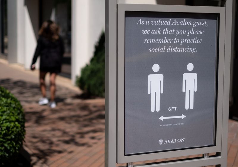 A sign at the Avalon outdoor shopping area in Alpharetta asks guests to maintain a 6-foot distance. Several shops at Avalon reopened to customers Friday morning.  Ben@BenGray.com for the Atlanta Journal-Constitution