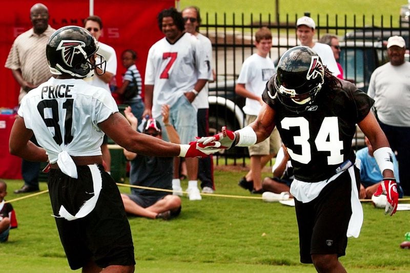 Former Falcons players Ray Buchanan and Peerless Price are scheduled to be at a Super Bowl viewing party at the College Football Hall of Fame on Sunday. This July 2003 photo shows them back in their days with the Falcons, as Atlanta Falcons wide receiver Price (left) gets five from cornerback Buchanan (right) after beating Buchanan for a long touchdown reception during training. CURTIS COMPTON/ ccompton@ajc.com