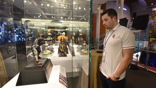Oklahoma quarterback Baker Mayfield looks at the Heisman  Trophy at the College Football Hall of Fame in Atlanta on Wednesday.