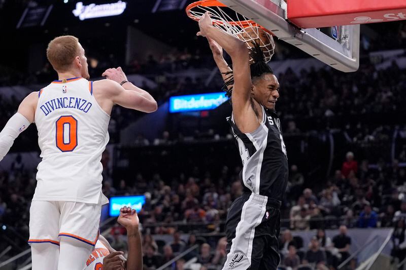 San Antonio Spurs guard Devin Vassell, right, scores past New York Knicks guard Donte DiVincenzo (0) during the second half of an NBA basketball game in San Antonio, Friday, March 29, 2024. (AP Photo/Eric Gay)