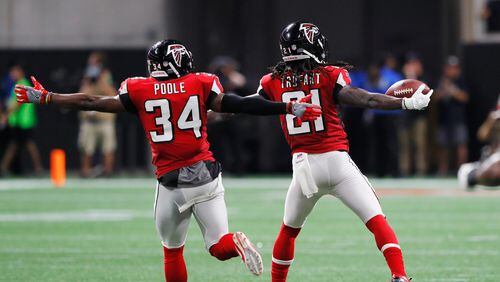 Falcons cornerback Desmond Trufant celebrates with Brian Poole after intercepting Aaron Rodgers of the Packers during the second quarter September 17 in Mercedes-Benz Stadium.