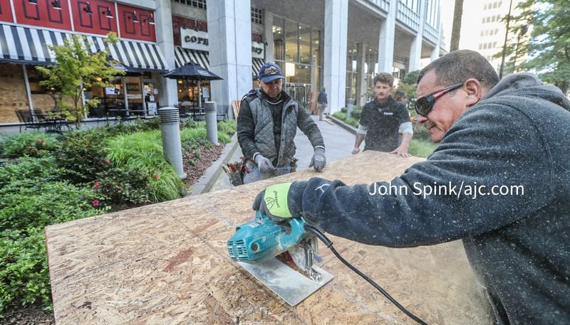 Left to right, Marco Castenia, Casey Brewer and Ony Garcia with Contract Builders board up Corner Bakery at 260 Peachtree in downtown Atlanta to protect the store from anticipated civil unrest.