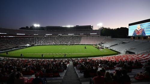 University of Georgia graduates and their families stay in the stands during the 2020 Spring Undergraduate Commencement ceremony at Sanford Stadium in Athens on Friday, October 16, 2020. The university practiced soial distancing guidelines for the ceremony and plans to do so again for this spring's ceremony in May. Several other colleges and universities in Georgia are planning in-person ceremonies next month. (Hyosub Shin / Hyosub.Shin@ajc.com)