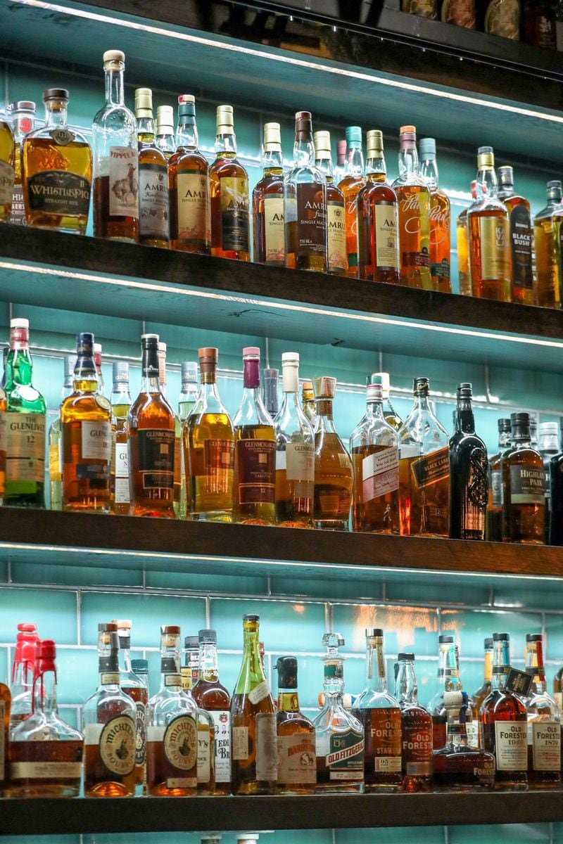 Three levels of shelves are shown stocked with a wide selection of liquor behind the bar at the Whiskey Project August 18, 2018, in Roswell, Georiga. PHOTO / JASON GETZ