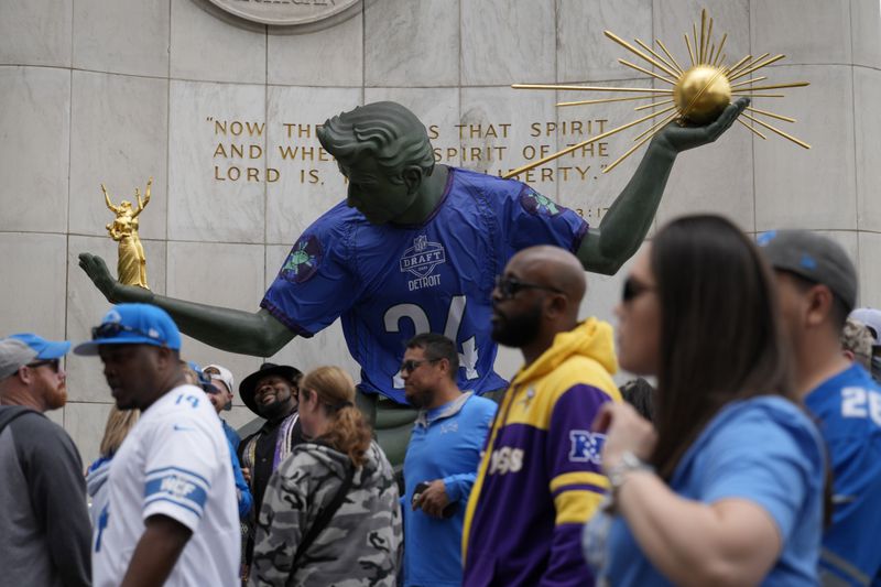 Fans walk by a statue during the third day of the NFL football draft, Saturday, April 27, 2024, in Detroit. (AP Photo/Jeff Roberson)