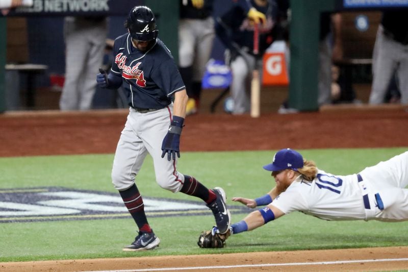 Braves shortstop Dansby Swanson is tagged out by a diving Los Angeles Dodgers third baseman Justin Turner on a run down between home plate and third base during the fourth inning Sunday, Oct. 18, 2020, of Game 7 of the National League Championship Series at Globe Life Field in Arlington, Texas. (Curtis Compton / Curtis.Compton@ajc.com)