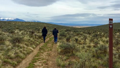Visitors to the National Historic Oregon Trail Interpretive Center outside Baker City, Ore., walk in the ruts formed when hundreds of thousands of pioneers crossed this route headed to the towering Blue Mountains. (Terri Colby/Chicago Tribune/TNS)