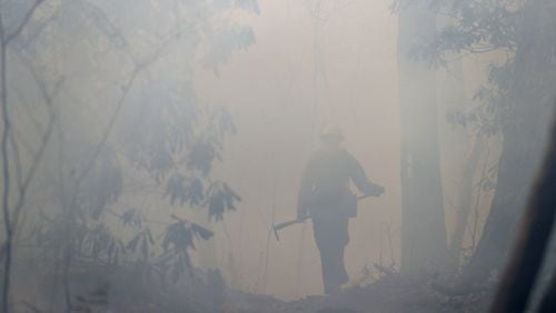 November 22, 2016, Tate City: California firefighter Zane Roberts is barely visable through heavy smoke while working to hold the northern head of the Rock Mountain Fire on the Appalachian Trail at Deep Gap on Tuesday, Nov. 22, 2016, north of Tate City and the North Carolina border. The area is deep in the Natahala National Forest. Curtis Compton/ccompton@ajc.com