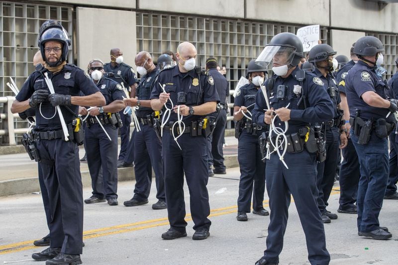 Atlanta police officers prepare zip tie handcuffs as a peaceful protest starts to turn violent outside of the CNN Center in Atlanta, on Friday, May 29, 2020. (Photo: ALYSSA POINTER / ALYSSA.POINTER@AJC.COM)