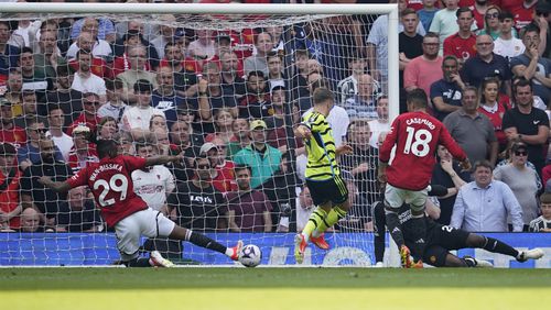 Arsenal's Leandro Trossard, centre, scores his side's opening goal during the English Premier League soccer match between Manchester United and Arsenal at the Old Trafford Stadium in Manchester, England, Sunday, May 12, 2024. (AP Photo/Dave Thompson)
