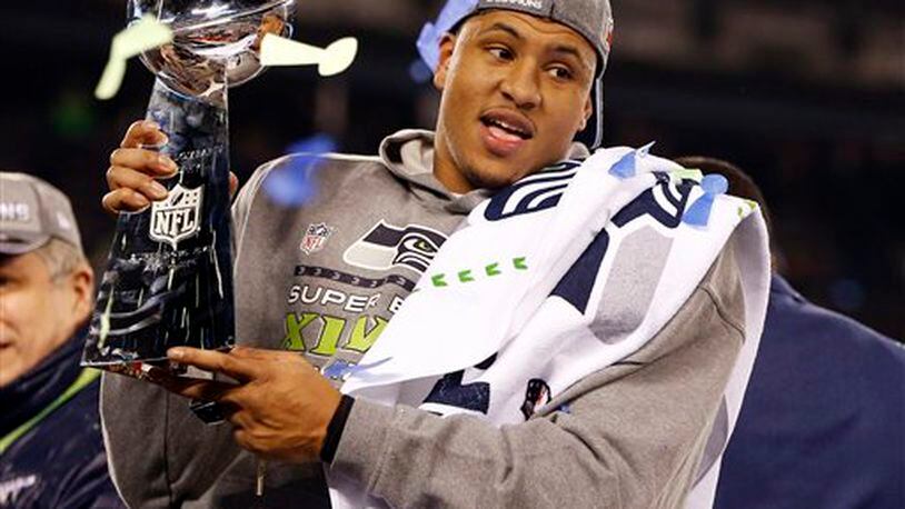 Seattle Seahawks' Malcolm Smith (53) holds the Vince Lombardi Trophy after the NFL Super Bowl XLVIII football game against the Denver Broncos, Sunday, Feb. 2, 2014, in East Rutherford, N.J. The Seahawks won 43-8. (AP Photo/Evan Vucci)