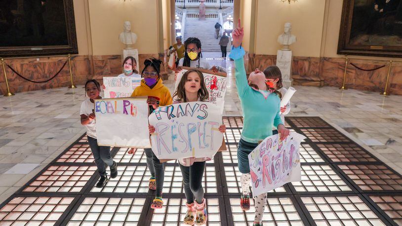 Students from the Morgan Oliver School hold signs in support of transgender youth at the Capitol in Atlanta on March 20. Activists visited the Gold Dome to protest SB 140, a bill that prevents medical professionals from giving transgender children certain hormones or surgical treatment. Gov. Kemp signed the bill on March 23. The new law goes effect in July. (Arvin Temkar / arvin.temkar@ajc.com)