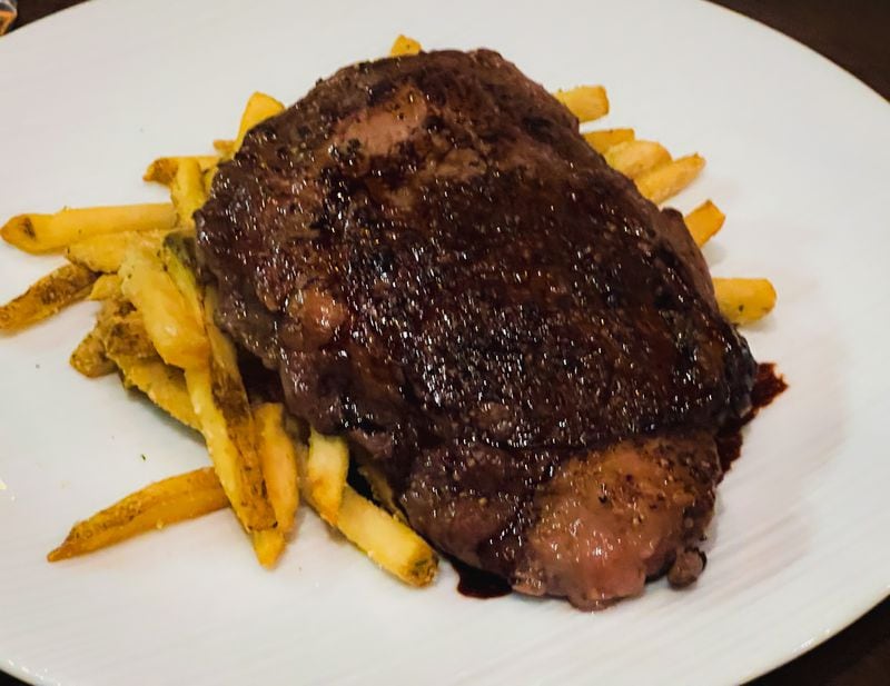 The 10-ounce rib-eye steak at Palm 78 is served on top of a mound of Parmesan fries. Henri Hollis/henri.hollis@ajc.com