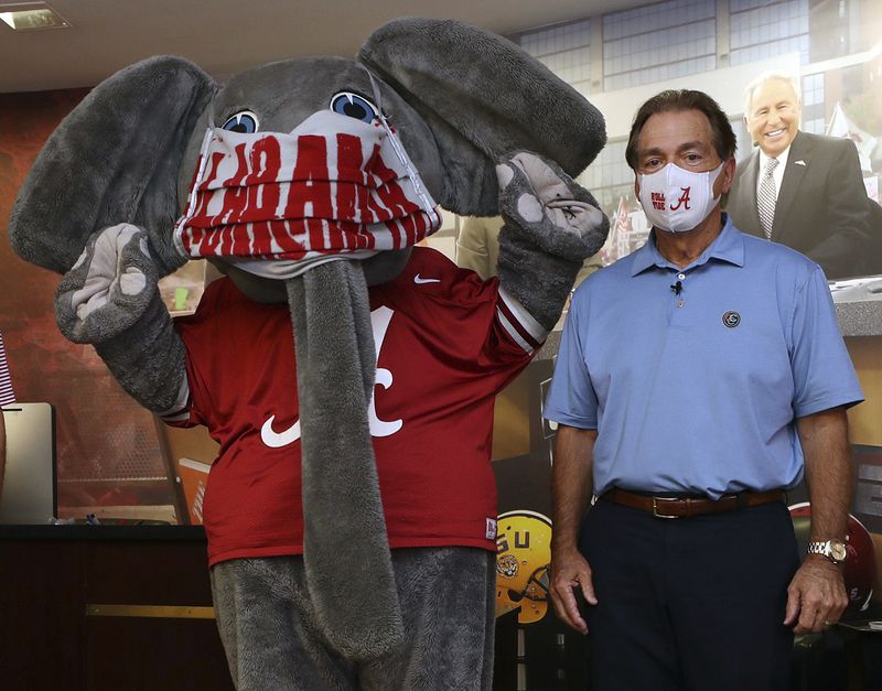 In this May 20, 2020 photo provided by the University of Alabama, football coach Nick Saban and the school's elephant mascot, Big Al, wear masks on the university campus in Tuscaloosa. Saban recorded a video promoting the use of face masks and social distancing. (AP Photo/Kent Gidley, University of Alabama via AP)