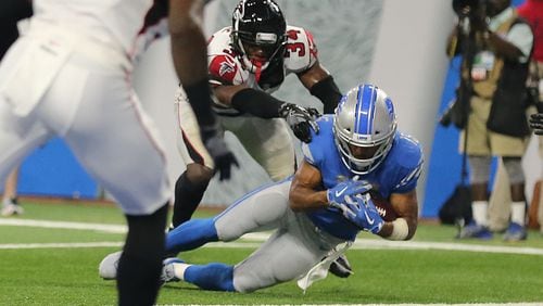 Golden Tate of the Lions catches the ball as Brian Poole of Falcons touches him and Tate's knee hits the ground during the fourth quarter at Ford Field on Sunday in Detroit. The play was originally ruled a touchdown with eight second left in the game. but was overturned after the officials viewed the play. With an ensuing 10-second runoff, the Falcons scored a 30-26 victory.