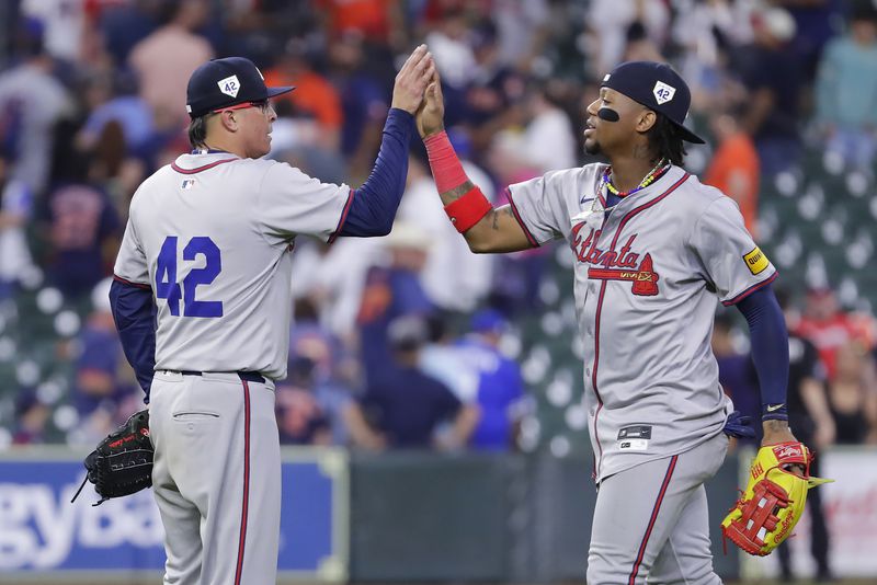 Atlanta Braves closing pitcher Jesse Chavez, left, high-fives right fielder Ronald Acuna Jr., right, after their win over the Houston Astros in a baseball game Monday, April 15, 2024, in Houston. All players wore No. 42 in honor of Jackie Robinson Day. (AP Photo/Michael Wyke)