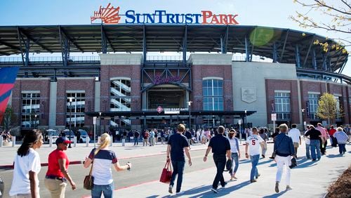 FILE - In this March 31, 2017, file photo, fans head to SunTrust Park before the Atlanta Braves open their new ballpark for an exhibition spring training baseball game against the New York Yankees, in Atlanta. After a short 20-year stay at Turner Field, the Braves begin their SunTrust Park era on Friday night, April 14 in their home opener against the San Diego Padres.  (AP Photo/David Goldman, File)