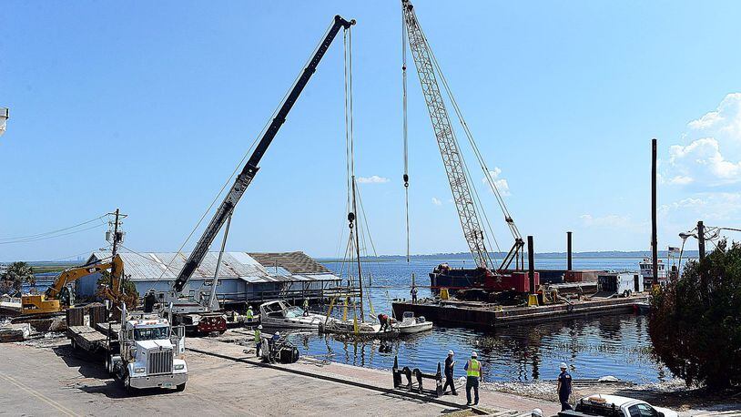 Cranes are set up on the waterfront in St. Mary’s as the U.S. Coast Guard and contractors remove boats, sunken and grounded by Tropical Storm Irma, to get the docks repaired and operating again. Photo from Sept. 27 2017. Terry Dickson/Florida Times-Union