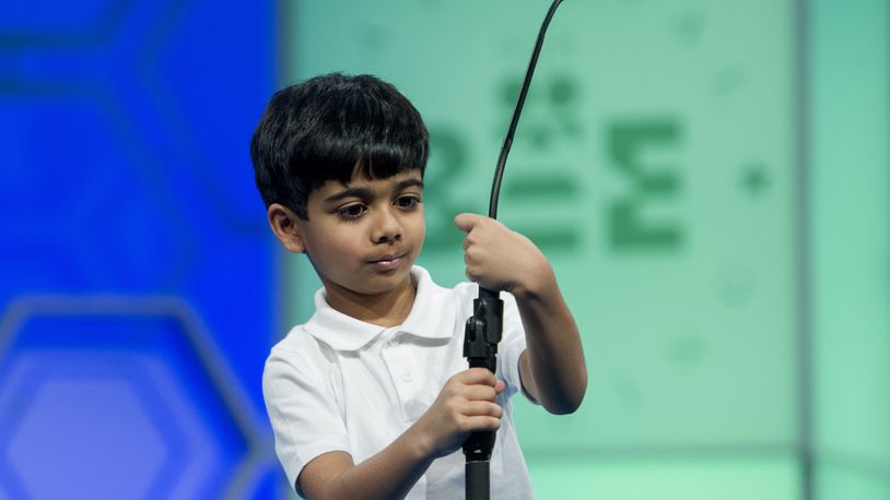 Akash Vukoti, 6, of San Angelo, Texas, tries to shorten the microphone before spelling his word during the preliminary round two of the Scripps National Spelling Bee in National Harbor, Md., Wednesday, May 25, 2016. Vukoti is the youngest speller in this year competition. (AP Photo/Cliff Owen)