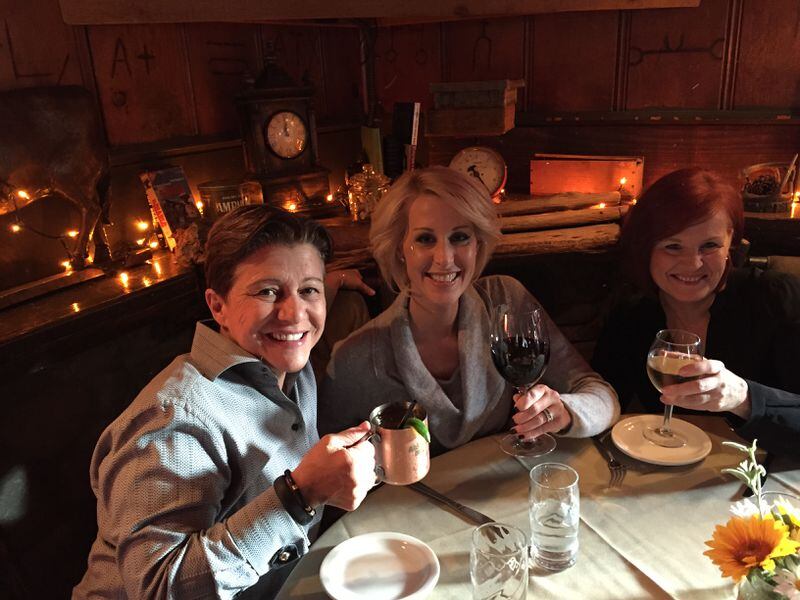 Michelle (center) enjoys a meal with her wife, Tena Clark  (left) and Michelle's  mother (right).