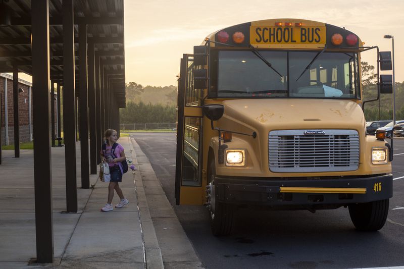 A student gets off the bus on the first day of school at Clark Creek Elementary School in Acworth, Georgia, on August 2, 2021. (Rebecca Wright for the Atlanta Journal-Constitution)