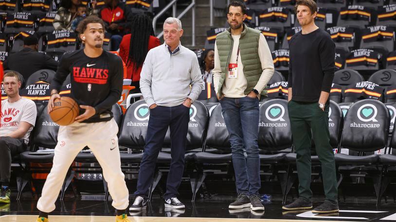 Hawks guard Trae Young prepares to shoot while (from left) Hawks owner Tony Ressler, general manager Landry Fields and assistant GM Kyle Korver watch before the Hawks’ game against the Cleveland Cavaliers at State Farm Arena, Friday, Feb. 24, 2023, in Atlanta.