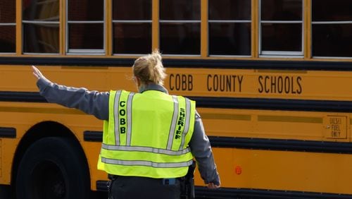 After the code red was lifted, Cobb County police officers blocked the traffic for buses from McEachern High School to keep moving. Two people were shot in the school's parking lot last week. This week, the community will gather to discuss school safety. (Miguel Martinez /miguel.martinezjimenez@ajc.com)