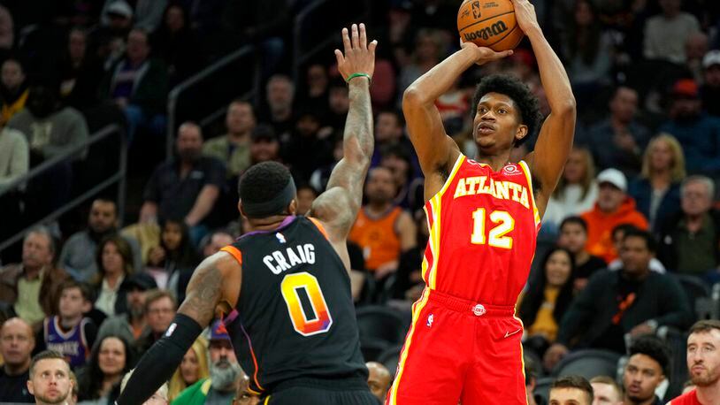 Hawks forward De'Andre Hunter shoots over Suns forward Torrey Craig during the first half Wednesday night in Phoenix. Though they still rank toward the bottom of the NBA in attempts per game (29.4), the Hawks are second in the league in 3-point efficiency (39.1) over the past 15 games. (AP Photo/Rick Scuteri)