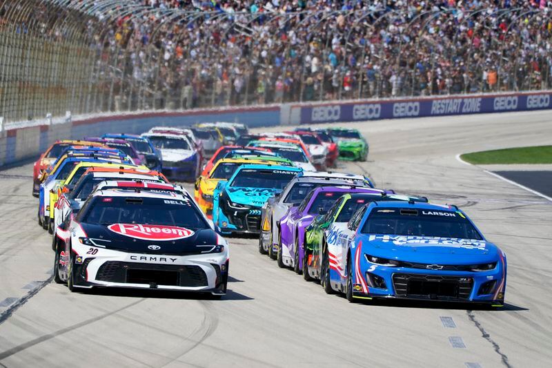 Christopher Bell (20) and Kyle Larson (5) lead the field into Turn 1 on a restart during the NASCAR Cup Series auto race at Texas Motor Speedway in Fort Worth, Texas, Sunday, April 14, 2024. (AP Photo/Larry Papke)