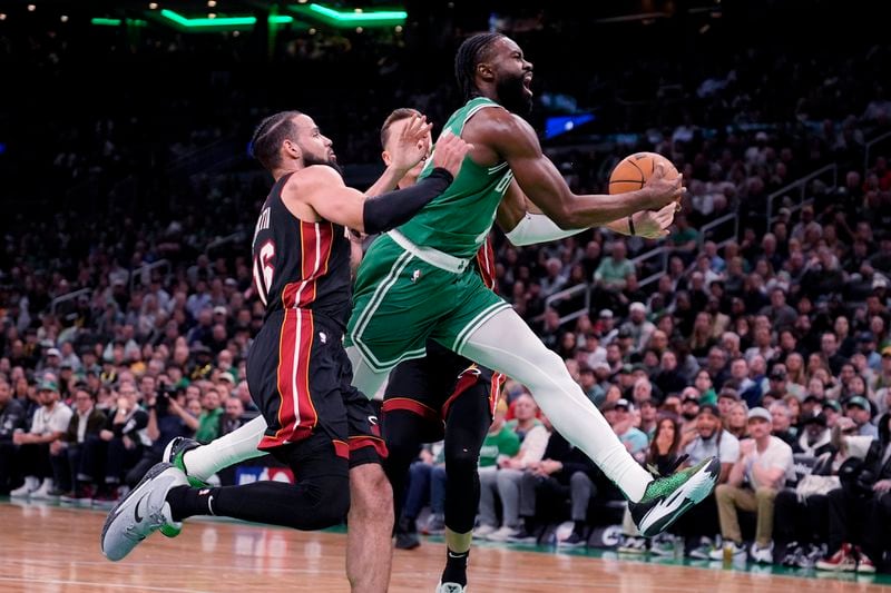Boston Celtics guard Jaylen Brown, right, drives to the basket against Miami Heat's Caleb Martin (16) during the first half of Game 2 of an NBA basketball first-round playoff series, Wednesday, April 24, 2024, in Boston. (AP Photo/Charles Krupa)