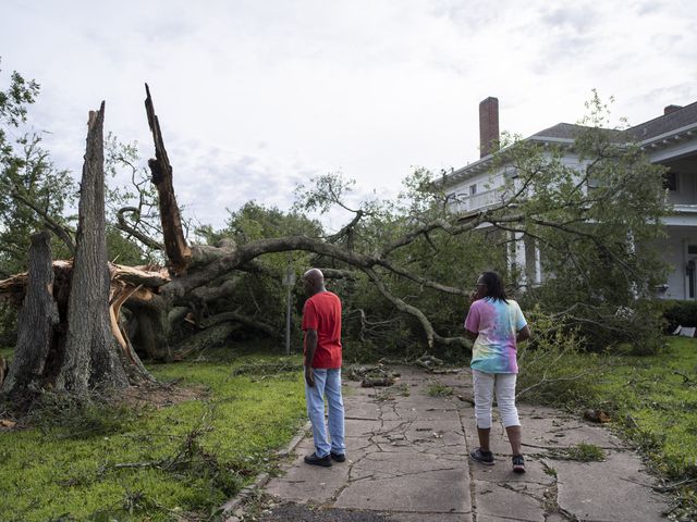 Anthony Williams, left, and his girlfriend Clara Lawrence, look at the damage done to trees at the Rose Hill Manor, one of the oldest historical landmarks in Port Arthur, Texas, on Thursday, Aug. 27, 2020, after Hurricane Laura passed through the area the area overnight. (Matthew Busch/The New York Times)