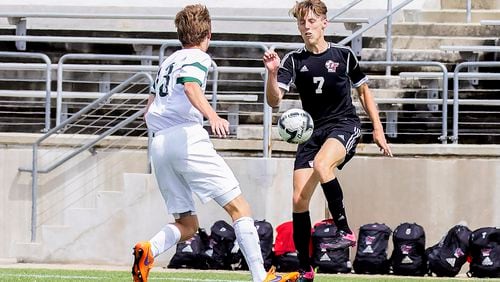 Lake Travis' Luke Thompson knee kicks the ball away from Woodlands'  Baker Smith during the Boys Region II playoff at Kelly Reeves Stadium March 24, 2016.