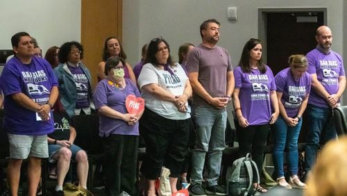 Demonstrators urged the Cobb County school board to embrace inclusivity. Speakers are not allowed to talk about issues related to employee discipline, but teacher Katie Rinderle, who read "My Shadow Is Purple" to fifth graders, and her impending termination hearing were the subtext of much of the July 20, 2023, meeting. From left (front row) are Micheal Garza, Nicole Kidwell, Erin Elwell, Kevin Redmon, Jennifer Susko, Melissa Marten, and Mike Marten. (Katelyn Myrick/katelyn.myrick@ajc.com)